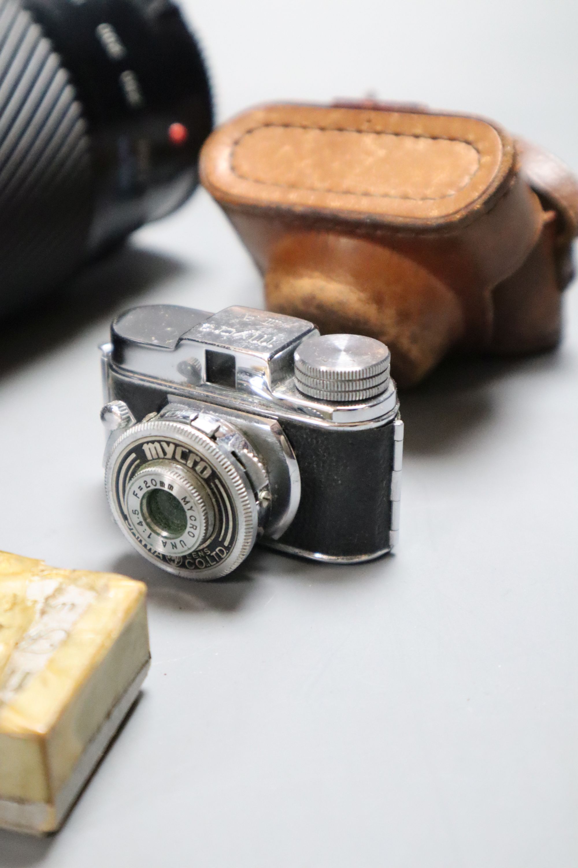 A Minolta 9000 SRL camera, a Minolta 75-300 zoom lens, with flash, together with a Sanwa Mycro miniature camera, with leather case